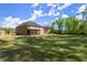 Wide shot of backyard features manicured lawn and screened in porch at 404 Prague Way, Hampton, GA 30228