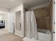 Well-lit bathroom featuring a tub shower combo with a curtain and a large mirror at 404 Prague Way, Hampton, GA 30228