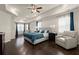 Spacious primary bedroom features tray ceilings, hardwood floors, sitting area, and ample natural light at 404 Prague Way, Hampton, GA 30228