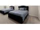 This bedroom has two twin-size beds that come with black headboards and stylish gray bedding at 404 Prague Way, Hampton, GA 30228