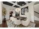 Dining room with a black coffered ceiling, stylish chairs, and a view into the adjacent kitchen at 404 Prague Way, Hampton, GA 30228