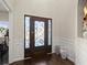 Stylish entryway with dark wood floors, decorative vases, and an ornate glass-paneled front door at 404 Prague Way, Hampton, GA 30228
