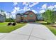Traditional brick home with a concrete driveway and lush green lawn, set against a wooded backdrop at 404 Prague Way, Hampton, GA 30228