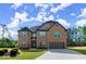 Elegant two-story brick home featuring a manicured lawn, attached garage, and driveway at 404 Prague Way, Hampton, GA 30228