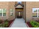 Close-up of a brick home's entrance, featuring an ornate front door and manicured landscaping at 404 Prague Way, Hampton, GA 30228