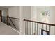 Upstairs hallway boasts sleek black railing and modern chandelier at 404 Prague Way, Hampton, GA 30228
