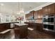 Gourmet kitchen features dark cabinetry, stainless steel appliances, granite countertops, and a center island at 404 Prague Way, Hampton, GA 30228