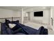 Open living area features plush blue couches, a modern media center, and plenty of natural light at 404 Prague Way, Hampton, GA 30228