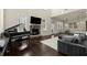 Open living room featuring a piano, fireplace, and comfortable seating area with hardwood floors at 404 Prague Way, Hampton, GA 30228