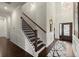 Elegant staircase with dark wood steps, white risers, and iron railings, complemented by classic wainscoting at 404 Prague Way, Hampton, GA 30228
