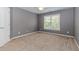 An empty bedroom with neutral walls, large window, and soft carpet, ready to be personalized for comfort and style at 4106 Creekview Ridge Ne Dr, Buford, GA 30518