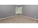 An empty bedroom with neutral walls, large window, and soft carpet, ready to be personalized for comfort and style at 4106 Creekview Ridge Ne Dr, Buford, GA 30518