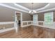 Formal dining room featuring hardwood floors, wainscoting, tray ceiling, and chandelier lighting at 4106 Creekview Ridge Ne Dr, Buford, GA 30518