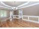 Formal dining room featuring hardwood floors, wainscoting, tray ceiling, and chandelier lighting at 4106 Creekview Ridge Ne Dr, Buford, GA 30518