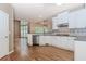 Bright, open kitchen with hardwood floors, white cabinets, stainless steel appliances, and granite countertops at 4106 Creekview Ridge Ne Dr, Buford, GA 30518