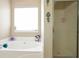 Bathroom with a soaking tub, window, and shower at 45 Hunters Ridge Ct, Covington, GA 30014