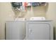 Bright laundry area features modern washer and dryer with wire rack shelving for storage at 45 Hunters Ridge Ct, Covington, GA 30014