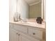 Bright bathroom featuring white cabinets, a neutral countertop, and a large framed mirror at 498 Trip St, Grayson, GA 30017