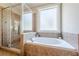 Bright bathroom featuring a glass shower, soaking tub, and a large frosted window at 498 Trip St, Grayson, GA 30017