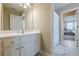 Well-lit bathroom featuring a large mirror and a view into an adjacent bedroom through an open doorway at 498 Trip St, Grayson, GA 30017