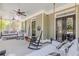 Inviting covered porch with rocking chairs, swing seating, and ceiling fans for relaxing outdoors at 498 Trip St, Grayson, GA 30017