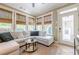 Cozy sunroom with a comfortable sectional sofa and plenty of natural light from large windows at 498 Trip St, Grayson, GA 30017