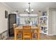 Bright dining area with a wooden table, modern lighting, and a built-in wine cooler, ideal for entertaining guests at 3127 Hidden Forest Dr, Snellville, GA 30078