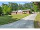 Charming brick home featuring a long driveway, lush lawn and mature trees at 3127 Hidden Forest Dr, Snellville, GA 30078