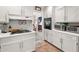 Functional kitchen features white cabinets, a gas cooktop, and essential appliances for efficient meal preparation and cleanup at 3127 Hidden Forest Dr, Snellville, GA 30078