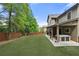 Serene backyard featuring lush lawn, fenced perimeter, covered patio, and outdoor lounge with a hot tub at 3599 Bellmonte Dr, Atlanta, GA 30337