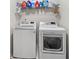 Functional laundry room featuring a washer, dryer, storage shelves, and an efficient design at 3599 Bellmonte Dr, Atlanta, GA 30337