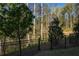 A view of a backyard featuring a black metal fence with a wooded, natural area just beyond the fence line at 518 Scenic Pass, Woodstock, GA 30189