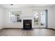 Bright living room featuring a cozy fireplace, large windows, and access to the outside patio at 6703 Gallant Se Ct, Mableton, GA 30126