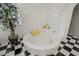 Bright bathroom featuring a round jacuzzi tub and a large arched doorway at 725 Links View Dr, Sugar Hill, GA 30518
