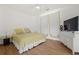 Bright bedroom featuring hardwood floors, large bed with bright, sunny yellow linens, and large windows at 725 Links View Dr, Sugar Hill, GA 30518