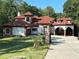 Stunning home featuring a tile roof, arched entryway, and lush landscaping at 725 Links View Dr, Sugar Hill, GA 30518