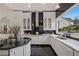 A chef's kitchen features modern white cabinetry and black countertops at 725 Links View Dr, Sugar Hill, GA 30518