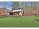 Rear of lot features outbuilding, swing, and lush landscaping in this beautiful backyard at 725 Links View Dr, Sugar Hill, GA 30518