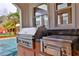 Built-in outdoor kitchen with stainless steel grill and granite countertop showcases al fresco dining at 725 Links View Dr, Sugar Hill, GA 30518