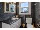 Powder room with dark granite walls, white cabinets, and silver fixtures at 725 Links View Dr, Sugar Hill, GA 30518