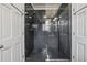 Dark granite tile walk-in shower with glass doors and multiple shower heads at 725 Links View Dr, Sugar Hill, GA 30518