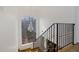 Staircase featuring wrought iron bannister, dark hardwood, and a bright chandelier in front of a large window at 725 Links View Dr, Sugar Hill, GA 30518