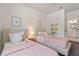 Inviting bedroom featuring twin beds, decorative pillows, and playful accents, adjacent to the bathroom at 1840 Wellston Dr, Lawrenceville, GA 30043