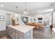 Bright, open kitchen with gray island, pendant lighting, quartz countertops, and hardwood flooring at 1840 Wellston Dr, Lawrenceville, GA 30043