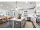 Open-concept kitchen with stainless steel appliances, white cabinets, gray island, and hardwood floors at 1840 Wellston Dr, Lawrenceville, GA 30043