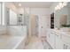 Luxurious primary bathroom featuring a soaking tub, a glass-enclosed shower, and dual vanities with modern fixtures at 1840 Wellston Dr, Lawrenceville, GA 30043