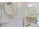 Bathroom featuring a vanity with marble countertop, round mirror and view to adjacent bedroom at 2000 Old Dominion Rd, Atlanta, GA 30350