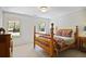 Cozy bedroom with wood frame bed, side tables, and two windows with views of the surrounding greenery at 2000 Old Dominion Rd, Atlanta, GA 30350
