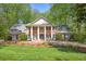 Beautiful brick home featuring a stately facade with large columns, lush landscaping, and a well-manicured lawn at 2000 Old Dominion Rd, Atlanta, GA 30350