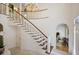 Grand foyer featuring a curved staircase, decorative chandelier, and elegant tile flooring at 2000 Old Dominion Rd, Atlanta, GA 30350